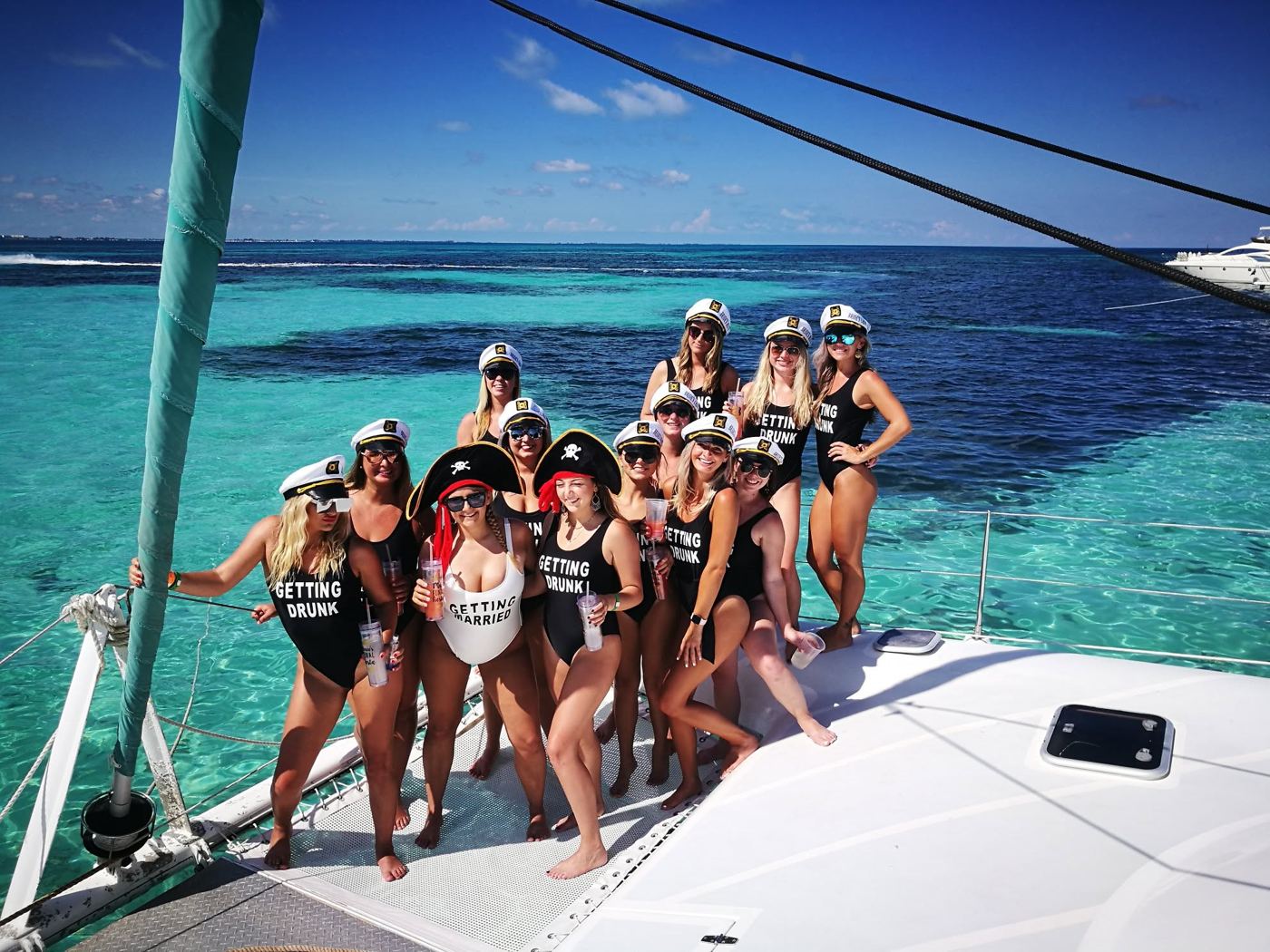 Despedida de soltera con gorras de capitán en la proa del catamarán