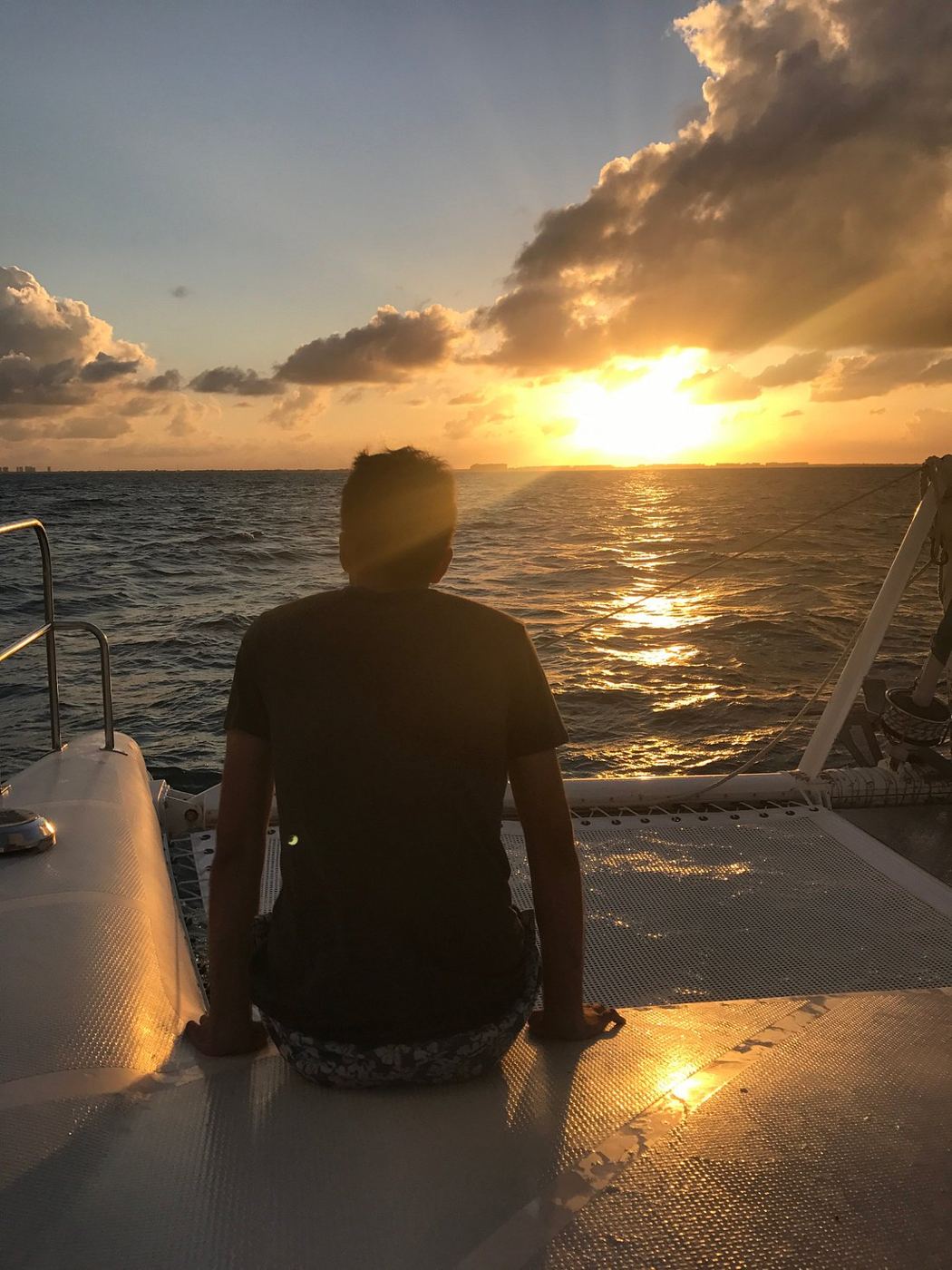 Silueta mirando el atardecer desde la proa