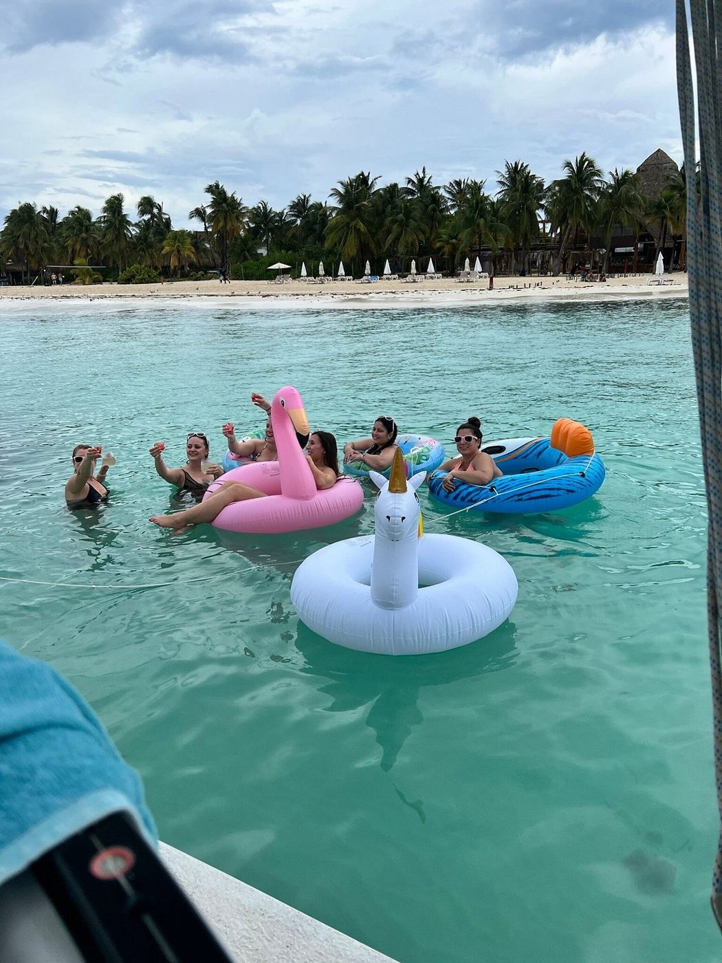 Flotadores en agua turquesa cristalina junto a la playa