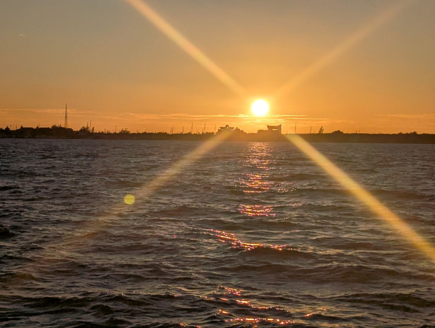 Destello del sol sobre el agua al anochecer